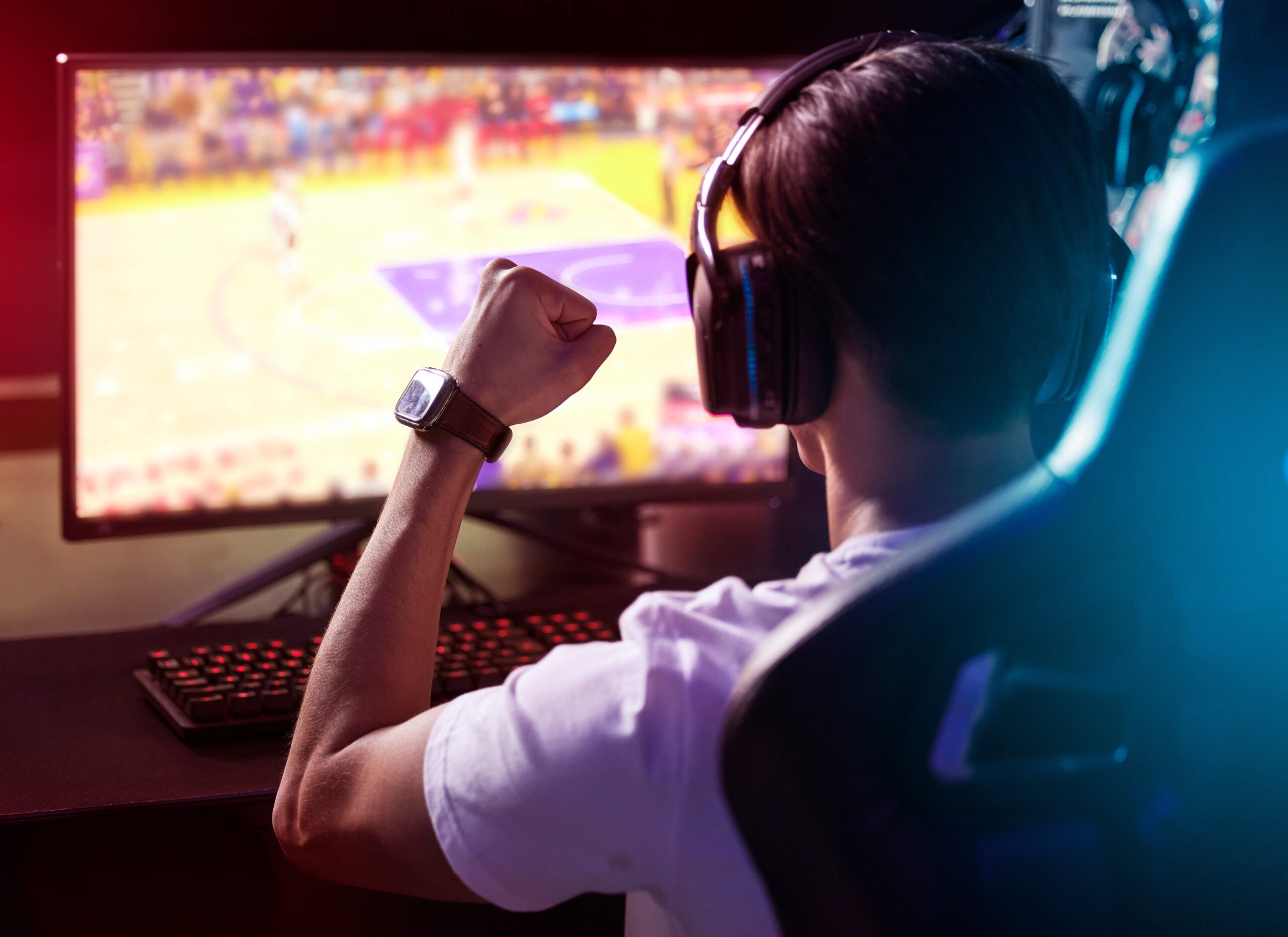 a young man cheering while playing computer games