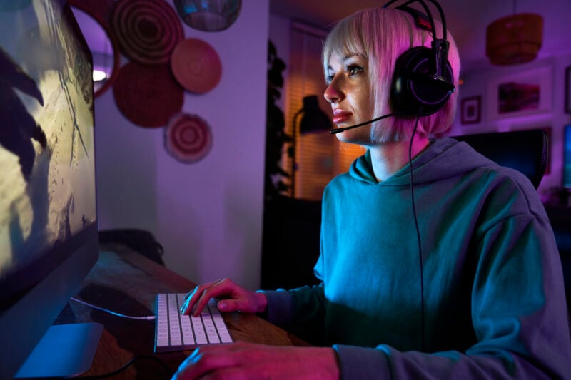 focused woman gaming online at home at night