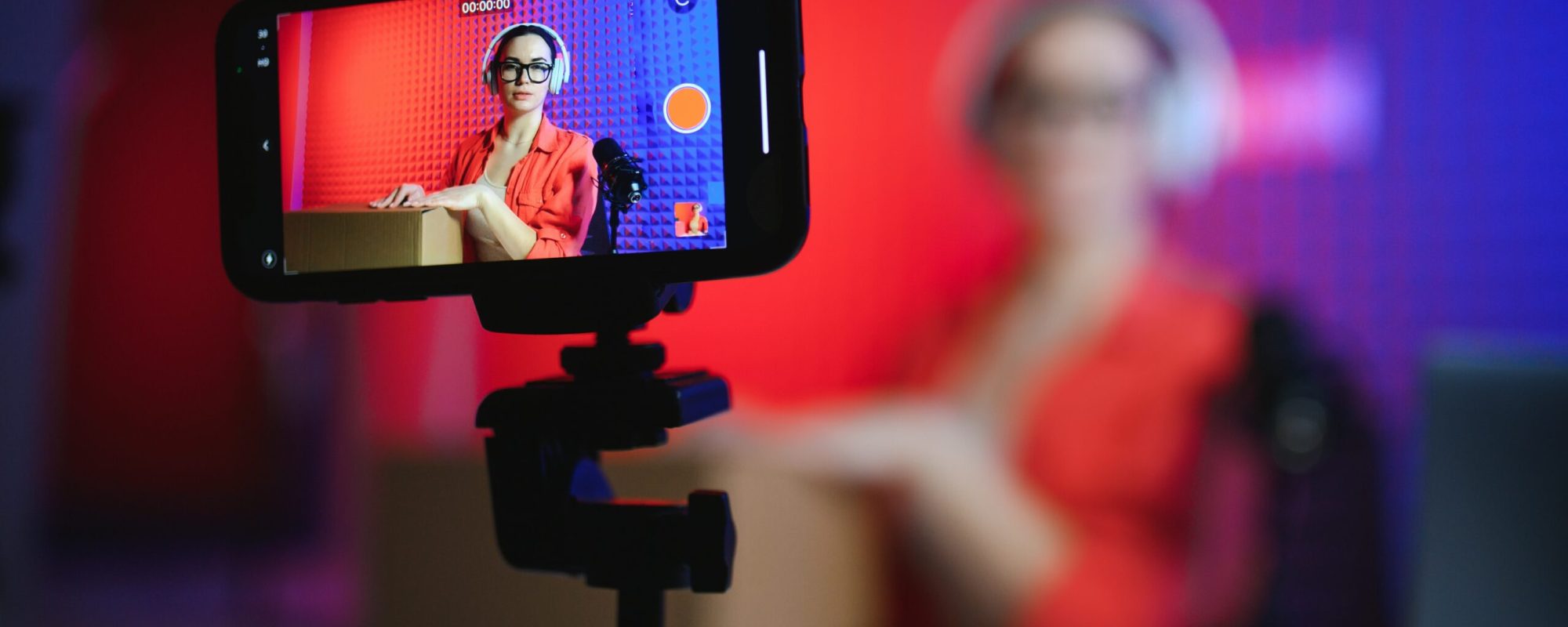 A young blogger girl records a video and unpacks a box with goods from an online store.