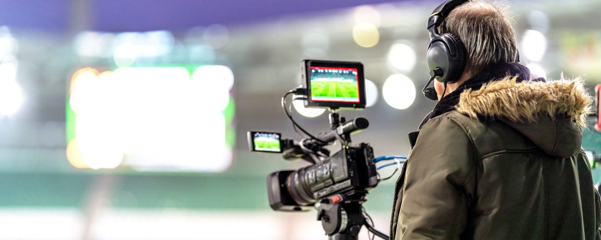 cameraman with a professional video camera on the broadcast of a football match