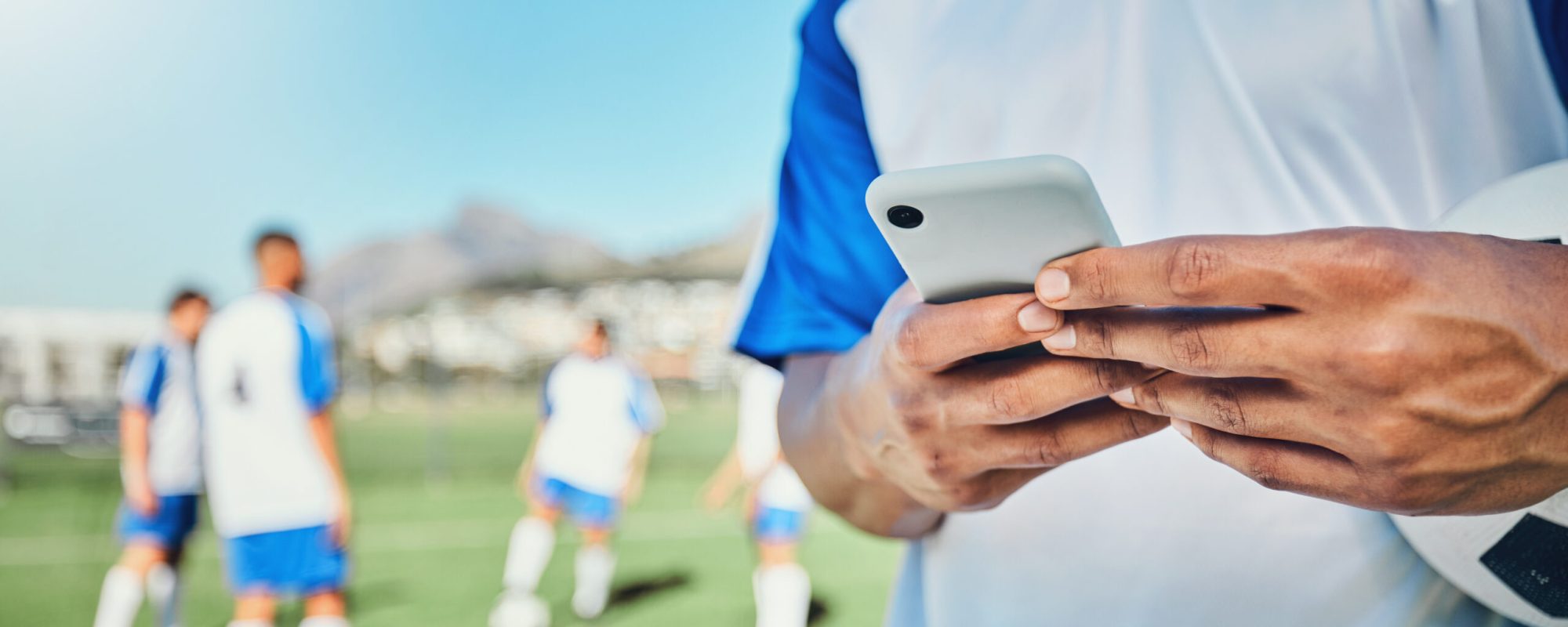 Football, field, phone and man hands for competition, training or fitness news, social media chat a.
