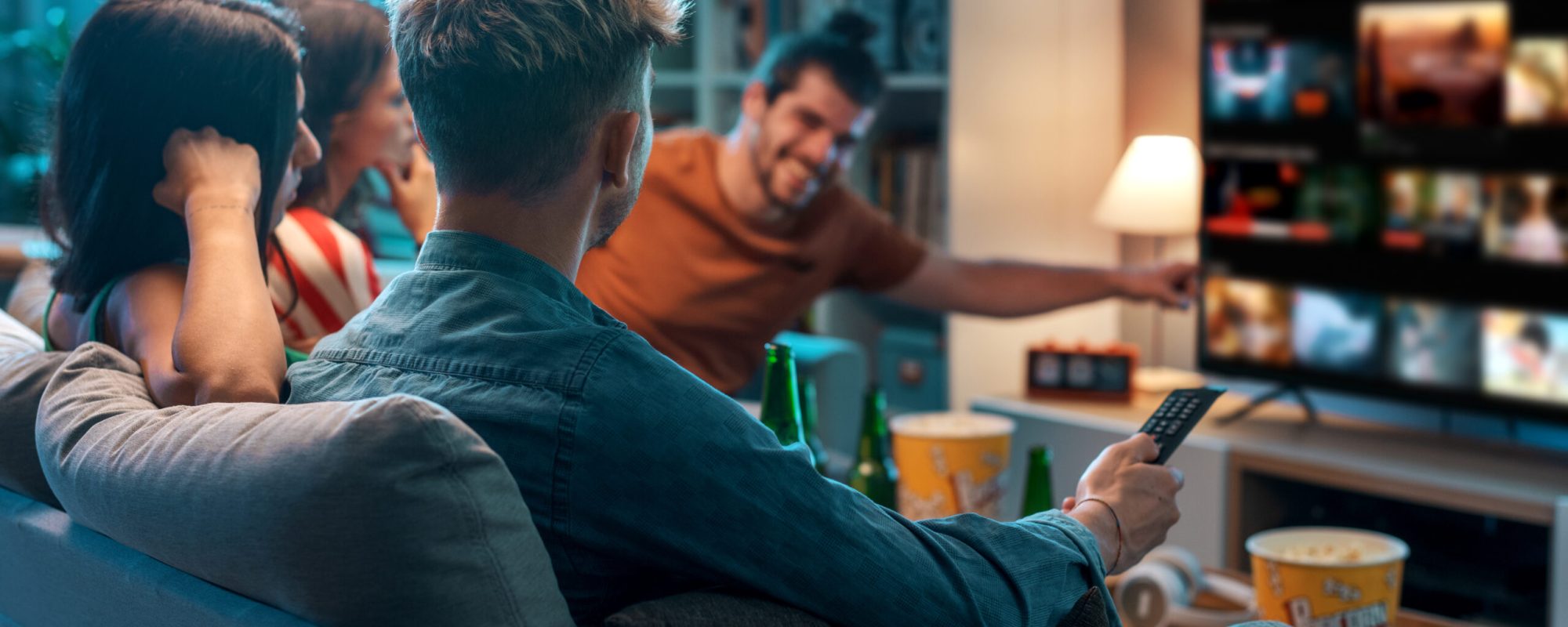 Friends choosing a movie to watch together at home, video on demand concept