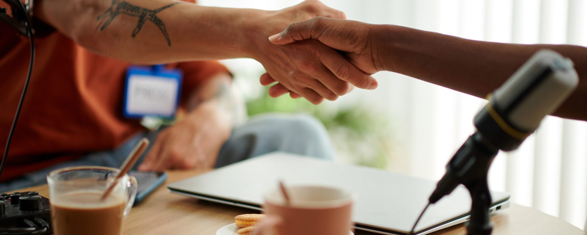 Podcaster and guest shaking hands before starting to record