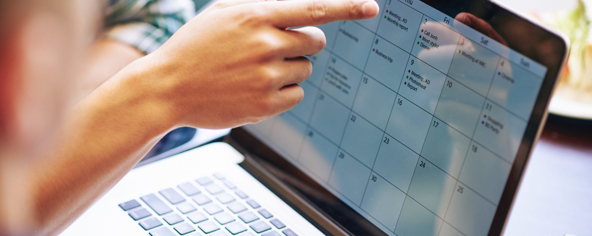 Close-up image of production team discussing working calendar for a month on laptop screen